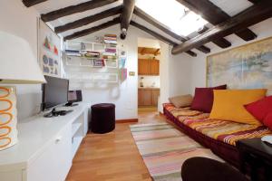 a living room with a couch and a tv at La Dimora Pantheon in Rome