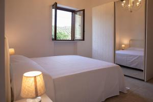 een slaapkamer met een wit bed en een raam bij Casale Manca - Luxury Country House - The quiet with a sea view in Licata