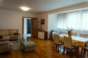 ein Wohnzimmer mit einem Tisch, Stühlen und einem Sofa in der Unterkunft Apartments Rozić in Mostar