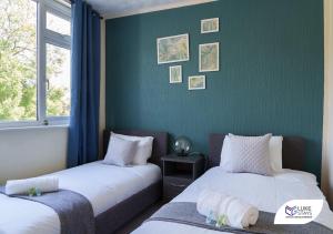 - 2 lits dans une chambre dotée d'un mur vert dans l'établissement Luke Stays - Cheveley Park, à Leamside