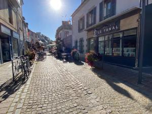 a cobblestone street with tables and chairs and buildings at Saint-Quay-Portrieux Grande Maison avec terrasse à 40m de la plage du port in Saint-Quay-Portrieux