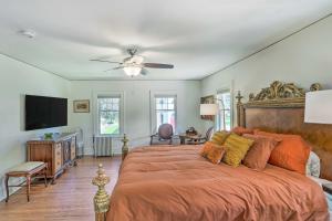 - une chambre avec un grand lit et un ventilateur de plafond dans l'établissement Historic Illinois Home Near Mississippi River, à Savanna
