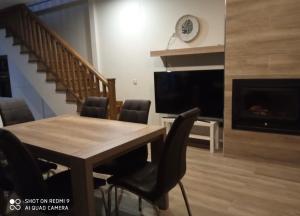 a dining room with a table and chairs and a fireplace at La Plaza Vieja in Cuevas del Valle