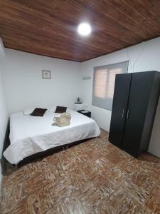 um quarto com uma cama e um tecto de madeira em KOMODO ALOJAMIENTO- hostal autoservicio - ubicado muy cerca al centro histórico -Habitaciones con baño privado, wifi , cama 2x2 em Popayán