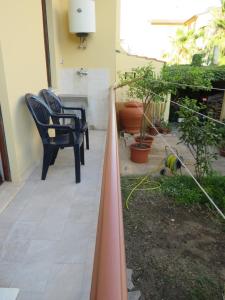 un patio con 2 sillas y una planta en Casa vacanze Aurora Tortolì en Tortolì