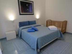 a bedroom with a blue bed with blue pillows at Casa vacanze Aurora Tortolì in Tortolì