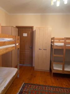 a room with two bunk beds and a door at Hostel 888 ALMATY in Almaty +3 photos