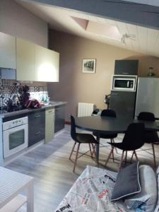 uma cozinha com mesa e cadeiras num quarto em Appartement terrasse +parking em Vieille-Brioude