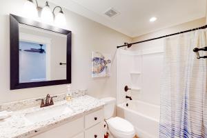 a bathroom with a sink and a toilet and a mirror at Beach Cottage East in Dauphin Island +19 photos