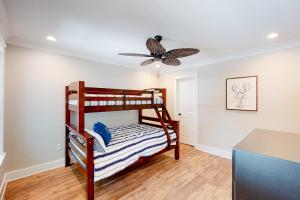 a bedroom with a bunk bed and a ceiling fan at Beach Cottage East in Dauphin Island
