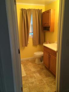 uma casa de banho com um WC, um lavatório e uma janela em Lodge at Kennebunk em Kennebunk