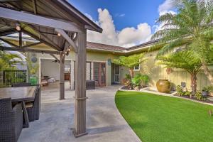 un patio con mesa y césped verde en Sunny Kailua Home with Covered Lanai 1 Mi to Beach! en Kailua