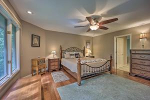 a bedroom with a bed and a ceiling fan at Lakefront Getaway with Private Dock and Kayaks! in Bella Vista +37 photos