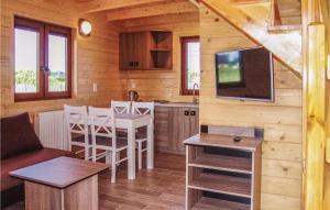 uma cozinha e sala de estar com uma mesa e uma televisão em Stunning Home In Gaski With Kitchen em Gąski