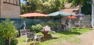 a group of chairs and umbrellas in a yard at Le Faubourg in Figeac