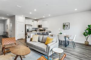 a living room with a couch and a kitchen at LUXURY TOWNHOME NEAR DOWNTOWN AND PENSACOLA BEACH in Pensacola