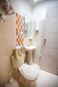 uma casa de banho com um WC e um lavatório em KOMODO ALOJAMIENTO- hostal autoservicio - ubicado muy cerca al centro histórico -Habitaciones con baño privado, wifi , cama 2x2 em Popayán