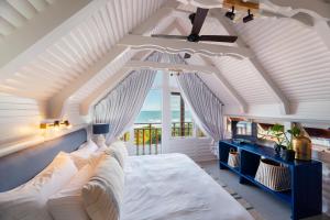 a bedroom with a white bed with a view of the ocean at Brenton on Sea Chalet in Brenton-on-Sea