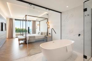 a white bathroom with a tub and a bedroom at ATTICA21 VIGO 4 Superior in Vigo