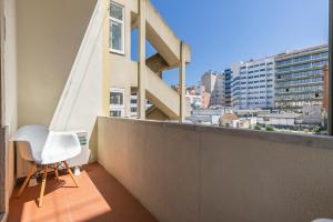una sedia bianca seduta sul balcone di un edificio di Saldanha Charming Palace a Lisbona