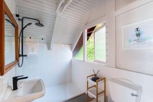 a white bathroom with a sink and a window at Brenton on Sea Chalet in Brenton-on-Sea