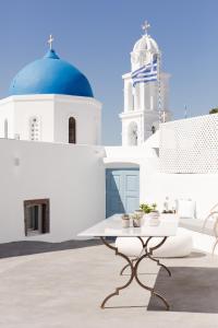 a table in front of a white building with a blue dome at Cydonia Caves in Megalokhori