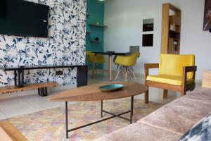 sala de estar con sofá, mesa y sillas en ROS’APPART, en Yaoundé