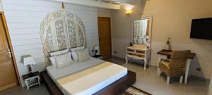 1 dormitorio con cama, escritorio y espejo en Couleurs du Sud en Vallon-Pont-dʼArc