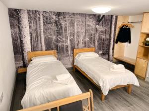 two beds in a room with a black and white wallpaper at Lodges at Flimwell Park in Ticehurst