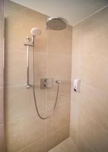a shower with a shower head in a bathroom at Lodges at Flimwell Park in Ticehurst