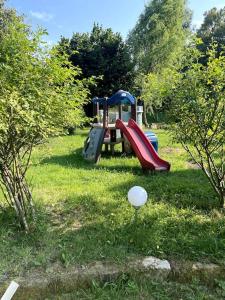 - une aire de jeux avec toboggan dans la pelouse dans l'établissement Apartament pod Brzozami, à Pławna