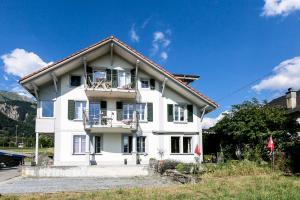 a white house with windows and a roof at Spirit Apartments - XXL-Apt mit Balkon und Seesicht in Brienz