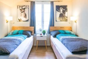 a bedroom with two beds and a window at Spirit Apartments - XXL-Apt mit Balkon und Seesicht in Brienz
