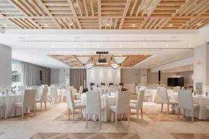 Una sala de conferencias con mesas y sillas blancas y un podio. en Attica21 Vigo 4 Superior, en Vigo