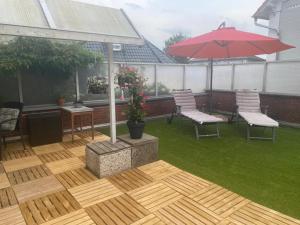 a patio with two chairs and a red umbrella at Marlene Ferienwohnung mit Dachterasse ca 50qm in Burg