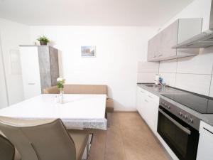 - une cuisine blanche avec évier et comptoir dans l'établissement Cozy holiday apartment on a farm in North Rhine Westphalia, à Jüchen