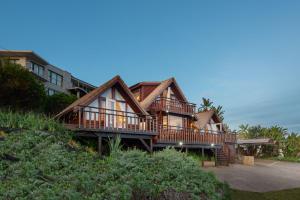 a large house with a wrap around deck at Brenton on Sea Chalet in Brenton-on-Sea