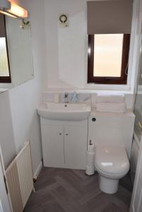 a white bathroom with a sink and a toilet at Kelpies Serviced Apartments- McLaughlan in Falkirk