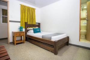 a bedroom with a large bed with a yellow curtain at Hotel La Terraza 2020 in Soacha