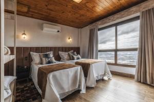 a bedroom with two beds and a large window at Discovery Canyon in Praia Grande