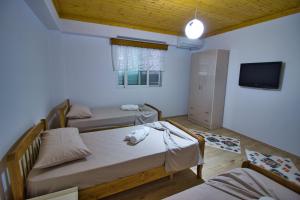 una piccola stanza con due letti e una tv di VILA SHAMETAJ a Gjirokastër