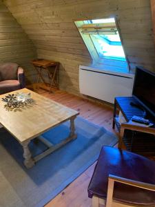 salon ze stołem i oknem w obiekcie Le clos gîte avec spa pour 2 personnes w mieście Beuzeville