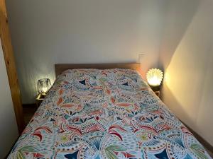 ein Bett in einem Schlafzimmer mit einer bunten Decke darauf in der Unterkunft Agréable maison 3* en bord de mer in Dieppe