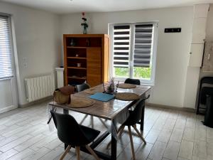 ein Esszimmer mit einem Holztisch und Stühlen in der Unterkunft Agréable maison 3* en bord de mer in Dieppe