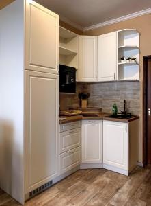 a kitchen with white cabinets and a refrigerator at Hanna Apartman in Balatonlelle