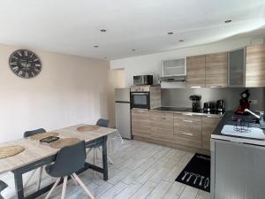 une cuisine avec une table et une horloge murale dans l'établissement Agréable maison 3* en bord de mer, à Dieppe