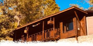 a log cabin with a porch and a balcony at Sukoon Nature Retreat Near Bhatrojkhan Ranikhet in Tota Ām