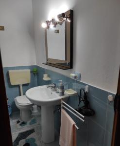 a bathroom with a sink and a toilet and a mirror at Casa Vacanza Di Maggio in Cinisi