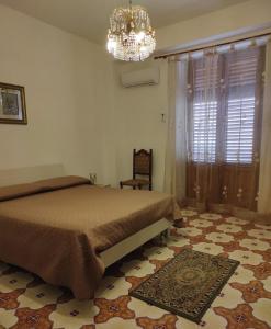 a bedroom with a bed and a chandelier at Casa Vacanza Di Maggio in Cinisi