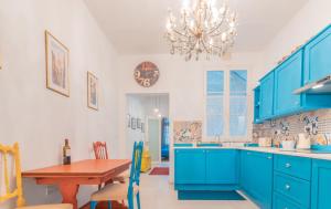 a blue kitchen with a table and a chandelier at Blue Waves Apartment with Maltese Balcony in Valletta
